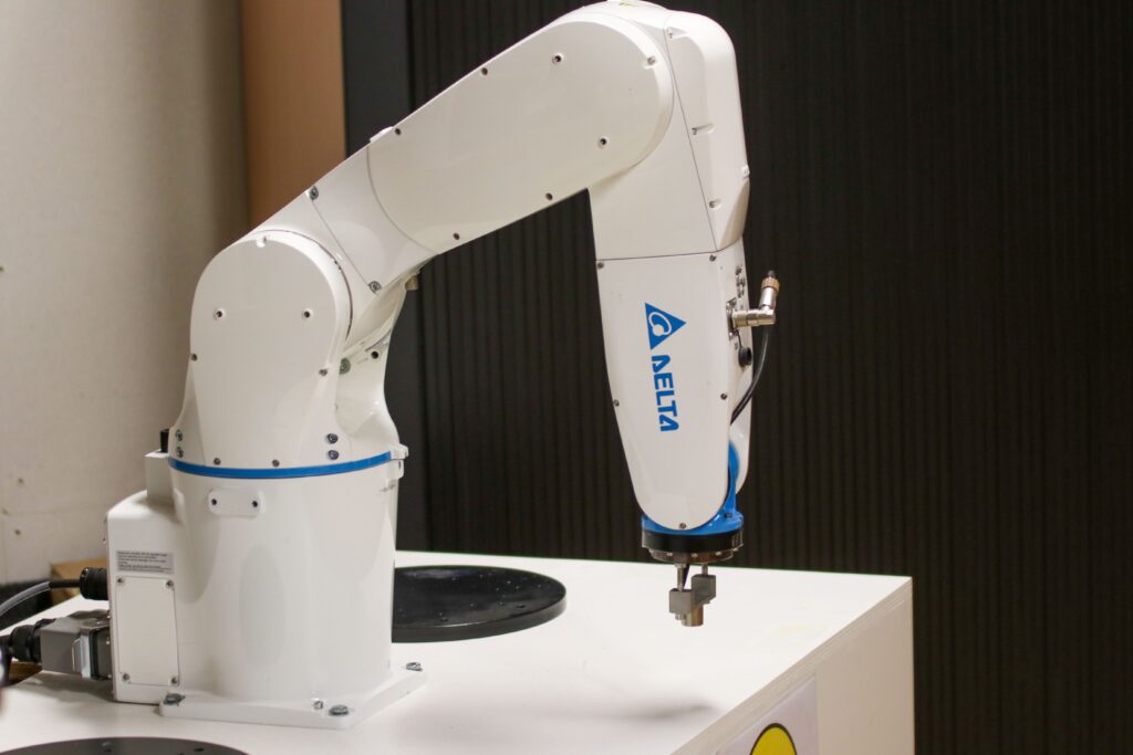 How AI and Automation Are Helping Businesses Work Smarter Close-up of a Delta brand robotic arm in an industrial setting, showcasing automation technology.